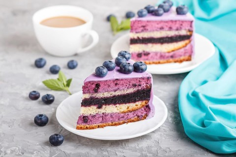 Homemade cake with souffle cream and blueberry jam with cup of coffee and fresh blueberries on a