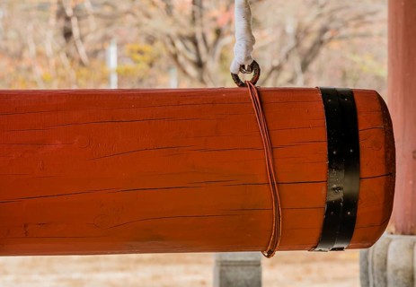 Closeup of large red wooden gong used at Buddhist temple to ring large bronze bell in South Korea