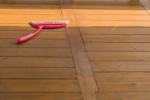 Red plastic broom laying on wooden picnic table in public park in South Korea