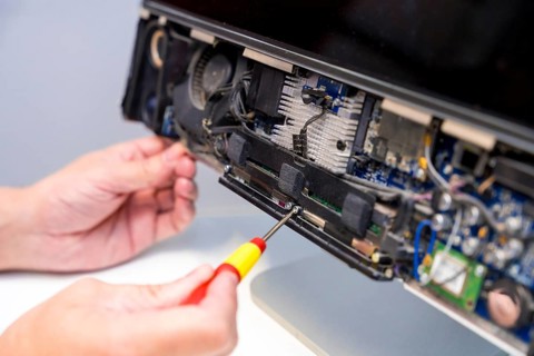Close-up of an unrecognizable technician fixing computer circuit board of a computer in a workshop