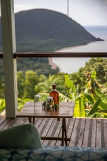 Rum limes and glasses on a table of a terrace in the foreground, in the background the beach Grande
