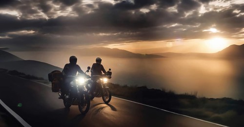 Two motorcyclist friends travel on motorcycles with panniers through the mountains at sunset, AI