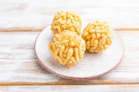 Traditional Tatar candy chak-chak made of dough and honey on a white wooden background. Side view,