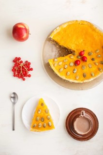 Traditional american sweet pumpkin pie decorated with hawthorn red berries and pumpkin seeds with