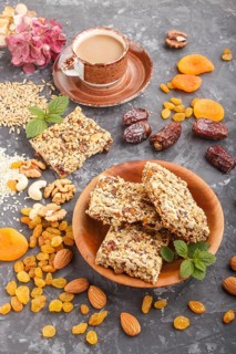 Homemade granola from oat flakes, dates, dried apricots, raisins, nuts with a cup of coffee on a