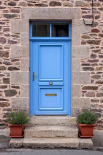 House facade with blue entrance door and two flower pots on steps, Pontrieux, Departement Cotes