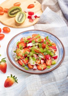 Vegetarian fruits and vegetables salad of strawberry, kiwi, tomatoes, microgreen sprouts on white