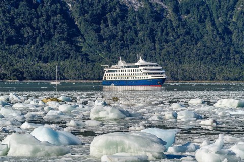 Cruise ship Stella Australis anchored between ice floes in Pia Bay in front of the Pia Glacier,