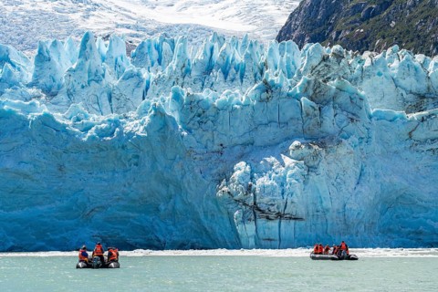 Passengers of the cruise ship Stella Australis in rubber dinghies in front of the ice of the Porter