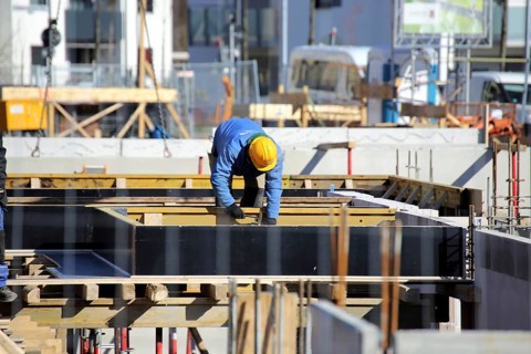 Construction work on the foundations of a large apartment building. The construction workers are