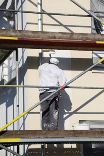Painter painting the facade of a new residential building (Mutterstadt development area,