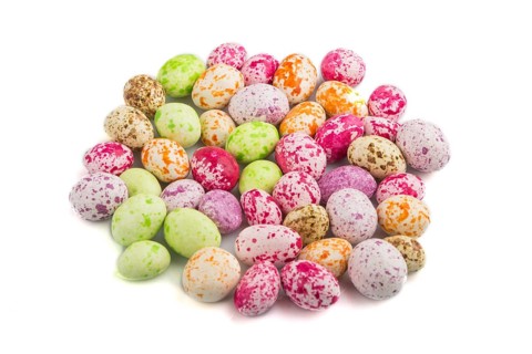 Pile of multicolored candies isolated on white background, chocolate dragees. close up, side view