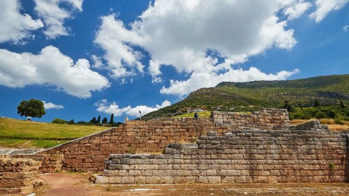 Ruins of an ancient wall in front of a light blue sky with fleecy clouds, Archaeological site,