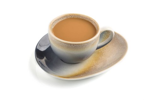 Cup of coffee with cream on ceramic plate isolated on white background, side view, close up