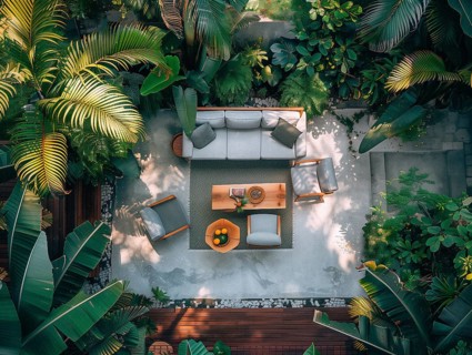 A serene courtyard with tropical plants, stone tiles, and comfortable outdoor furniture bathed in