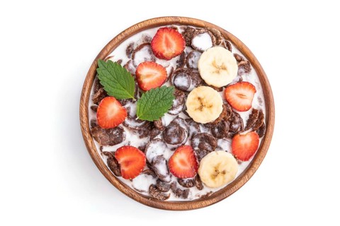Chocolate cornflakes with milk and strawberry in wooden bowl isolated on white background. Top