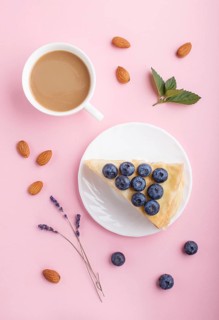 Homemade layered Napoleon cake with milk cream. Decorated with blueberry, almonds, mint on a pastel