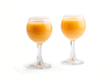 Sweet egg liqueur in glass isolated on white background. Side view, close up