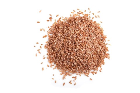 Heap of unpolished brown rice isolated on white background. Top view, flat lay, close up, macro