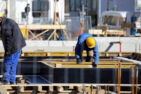 Construction work on the foundations of a large apartment building. The construction workers are