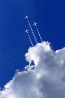 Three white passenger airplanes in blue sky