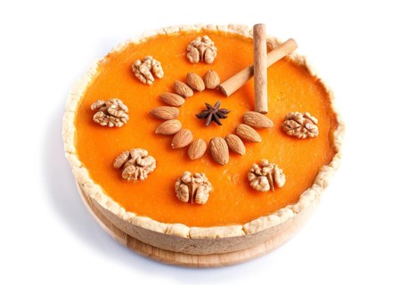 Traditional american sweet pumpkin pie decorated with nuts, isolated on white background. close up