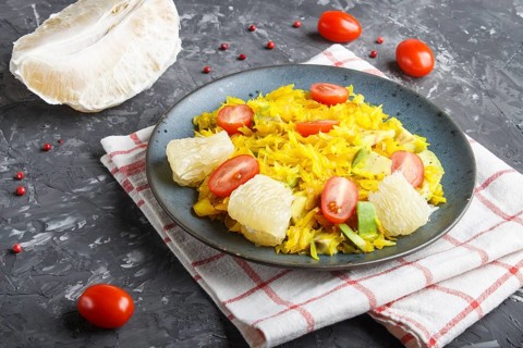 Fried pomelo with tomatoes and avocado on black concrete background. side view, myanmar food