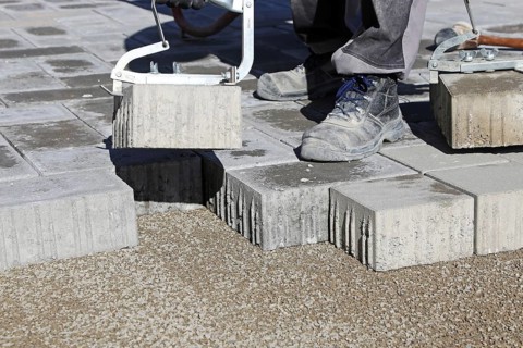 Workers lay paving stones