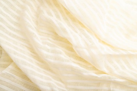 Fragment of white linen tissue. Top view, flat lay, natural textile background and texture. wave