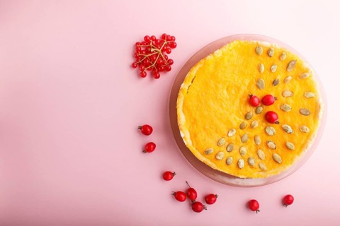 Traditional american sweet pumpkin pie decorated with hawthorn red berries and pumpkin seeds on a