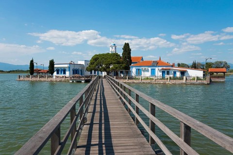 Monastery complex with church at the end of a bridge over calm water, Monastery of St Nicholas,
