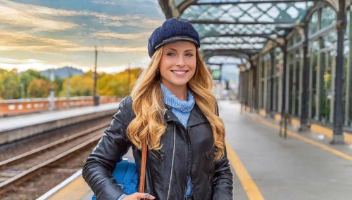 AI generated, A young blonde woman wants to travel and waits for the train at the station, 20, 25,