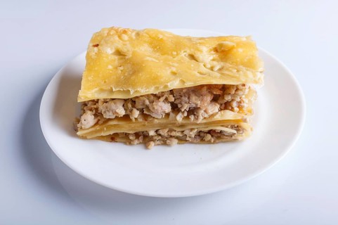 Lasagna with minced meat and cheese isolated on white background. close up