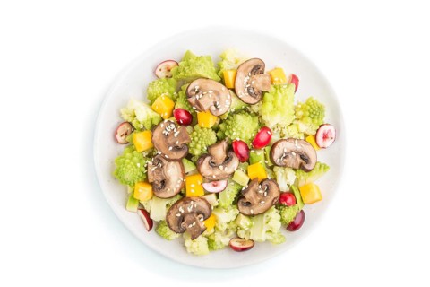 Vegetarian salad from romanesco cabbage, champignons, cranberry, avocado and pumpkin isolated on a
