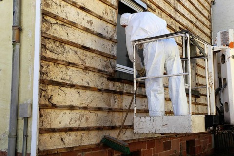 Professional asbestos removal by workers in protective suits