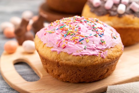 Homemade glazed and decorated easter pies with chocolate eggs and rabbits on a gray wooden