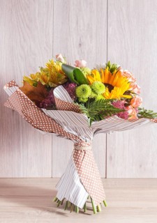 Bouquet of alstroemeria, sunflower, roses, chrysanthemum on a wooden background. floristic