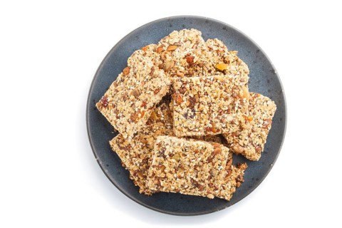 Homemade granola from oat flakes, dates, dried apricots, raisins, nuts in blue ceramic plate