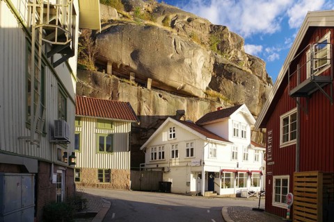 Small houses huddled under high rocks, Archipelago coast, Fjaellbacka, Vaestra, Goetlands, Sweden,