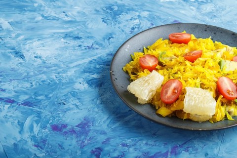 Fried pomelo with tomatoes and avocado on blue concrete background. side view, copy space, myanmar