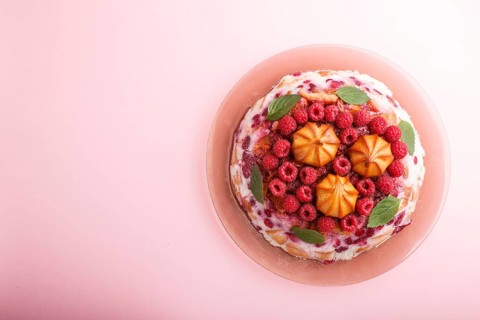 Homemade jelly cake with milk, cookies and raspberry on a pink background. top view. flat lay, copy