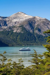 Cruise ship Stella Australis anchored between ice floes in Pia Bay in front of the Pia Glacier,