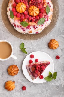 Homemade jelly cake with milk, cookies and raspberry on a gray concrete background with cup of