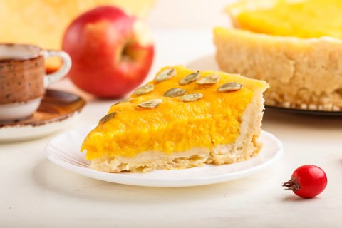 Traditional american sweet pumpkin pie decorated with hawthorn red berries and pumpkin seeds with