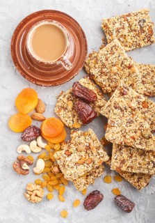 Homemade granola from oat flakes, dates, dried apricots, raisins, nuts with a cup of coffee on a