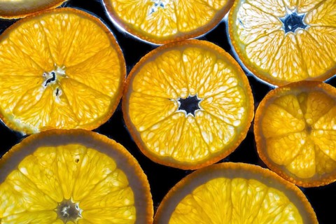 Transparent slices of fresh oranges and lemons on the glass