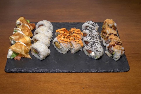 A slate plate hosting a variety of sushi rolls with different toppings and sauces, Majorca,