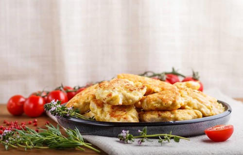 Minced chicken cutlets with herbs on brown wooden background. side view, copy space, selective