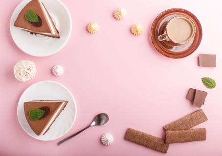 Cake with souffle milk chocolate cream with cup of coffee, meringues on a pink pastel background.