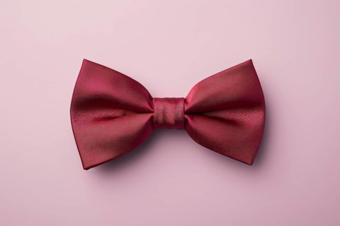 Burgundy red bow tie on pink background. KI generiert, generiert AI generated